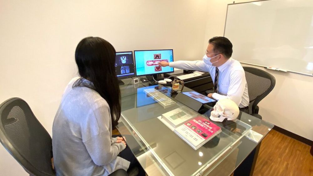 患者様に説明を行う歯科医師